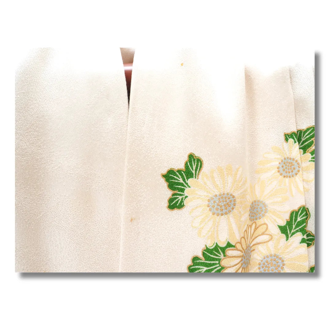 Detailaufnahme des Kragenbereichs mit Blütenmotiv, kleiner Fleck