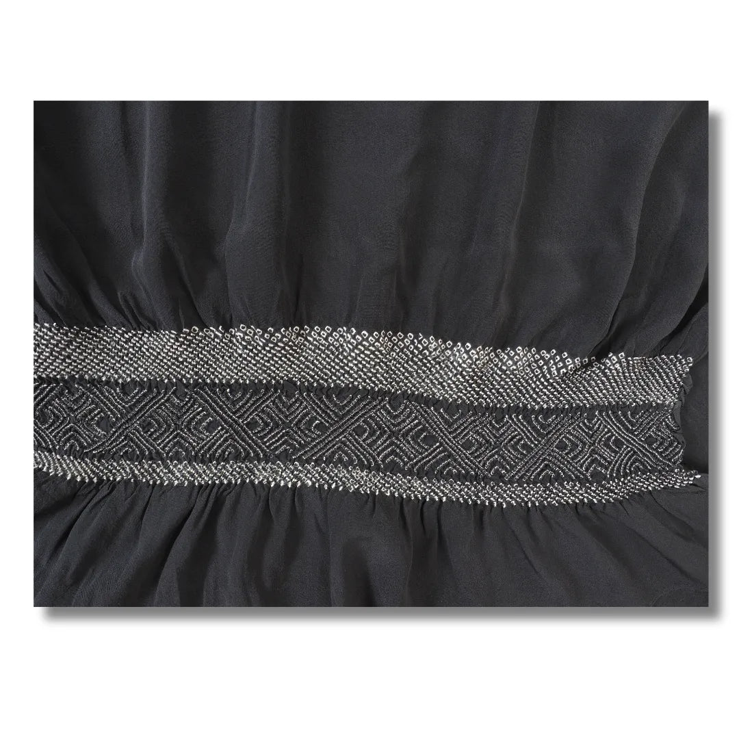 Gekräuseltes Shibori-Musterband zwischen glattem dunkelgrauem Stoff