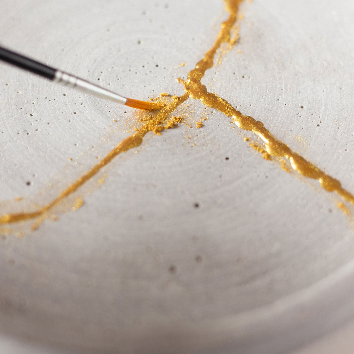 goldene Kintsugi Farbe wird auf einen Teller aufgetragen #farbe_Gold