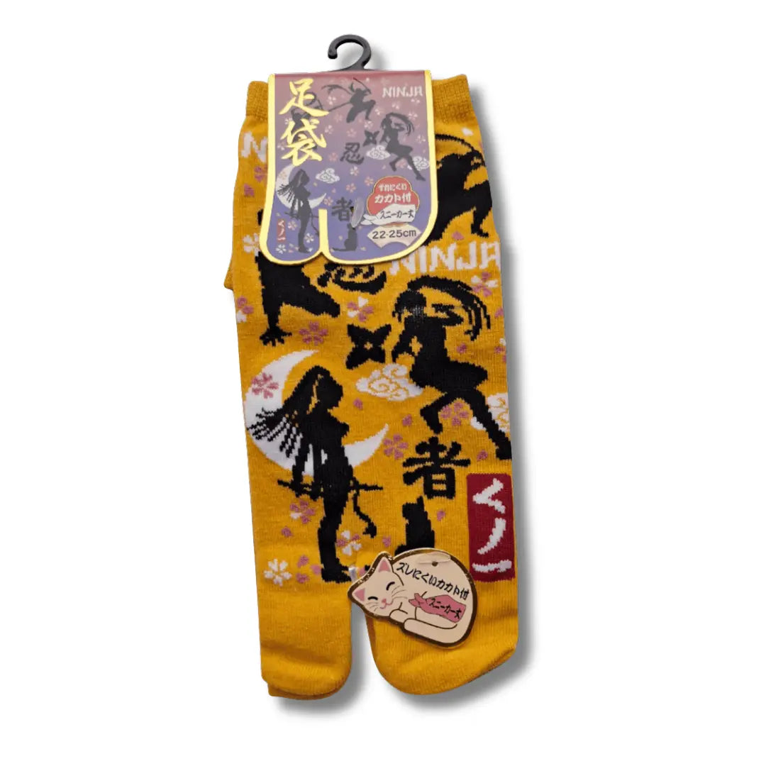 Detailaufnahme der Oberseite eines gelben Paares kurzer japanischer Tabi Sneaker-Socken mit Kunoichi-Ninja-Druck und Shuriken-Mustern. #farbe_Gelb