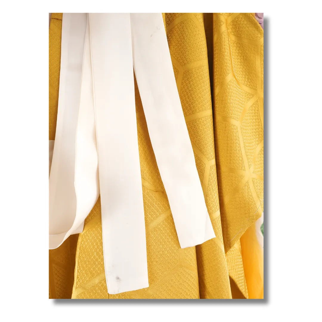 Nahaufnahme der weißen Bänder am senfgelben Vintage Kinder-Kimono