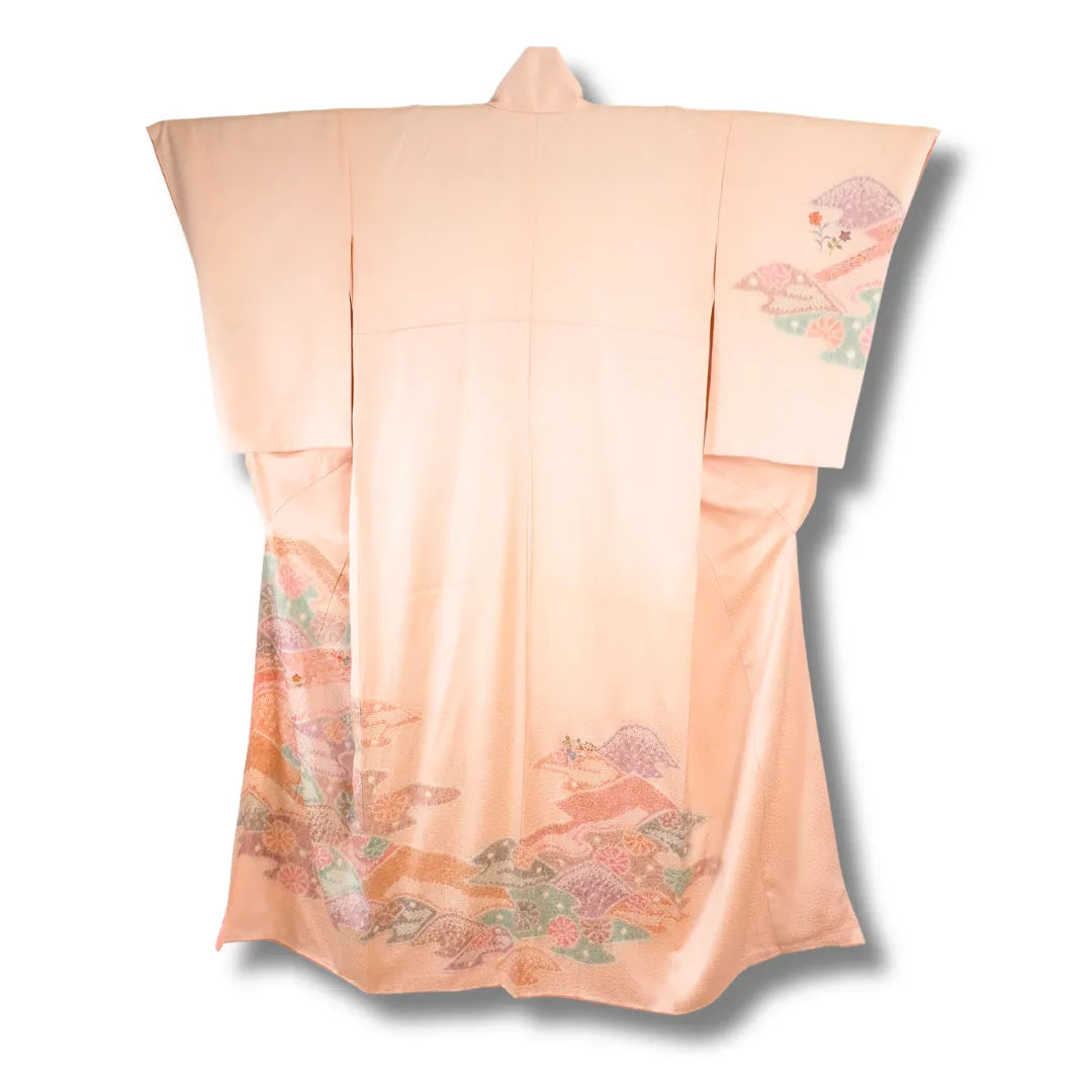 Rosafarbener Vintage-Kimono hängend, großes Blütenmotiv am unteren Saum sichtbar