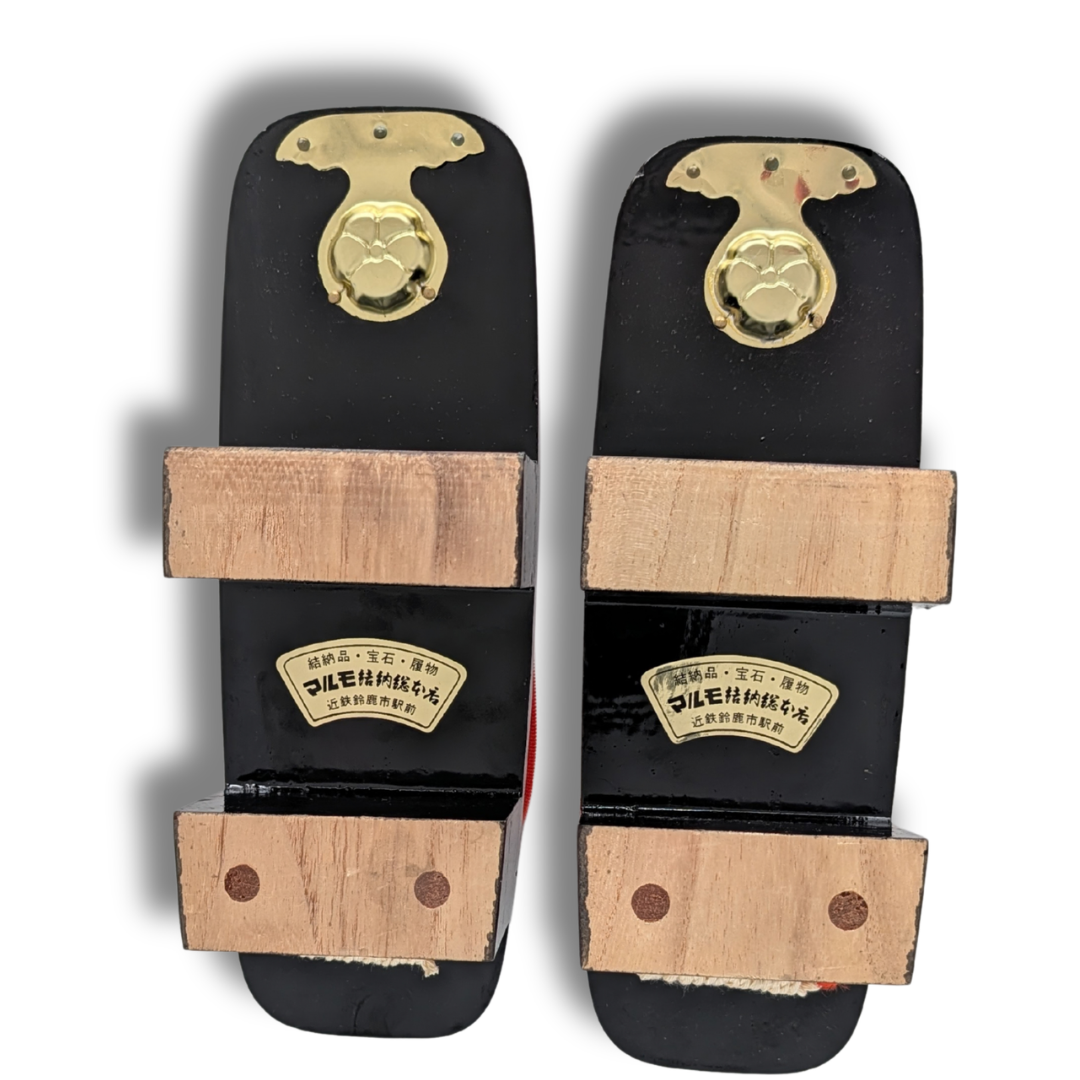 Unterseite der schwarzen Vintage Damen Geta aus Japan mit zwei erhöhten Holzstegen und goldfarbenen japanischen Details