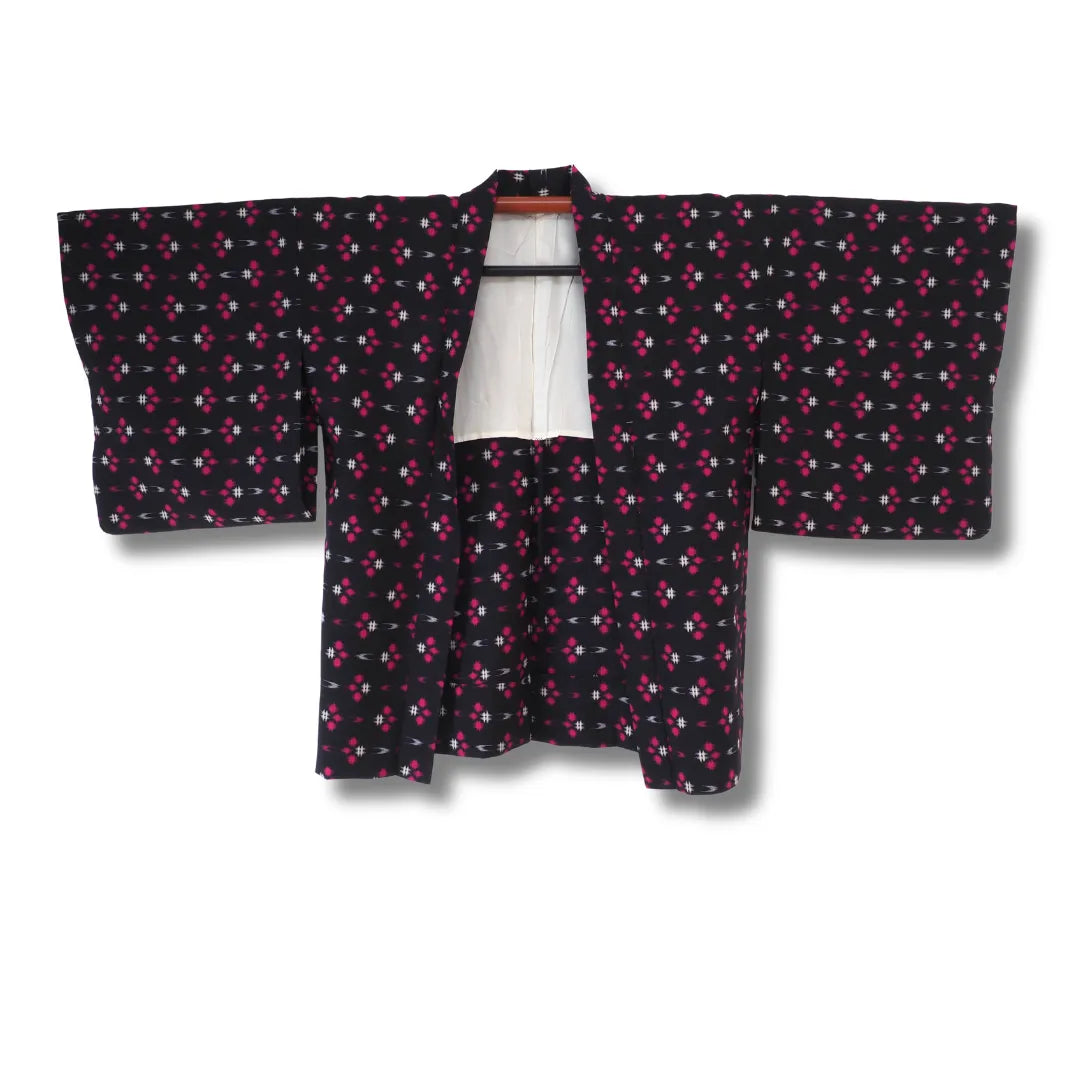 Vintage Damen Haori in Schwarz mit pink-weißem geometrischem Muster, geöffnet mit weißem Futter sichtbar
