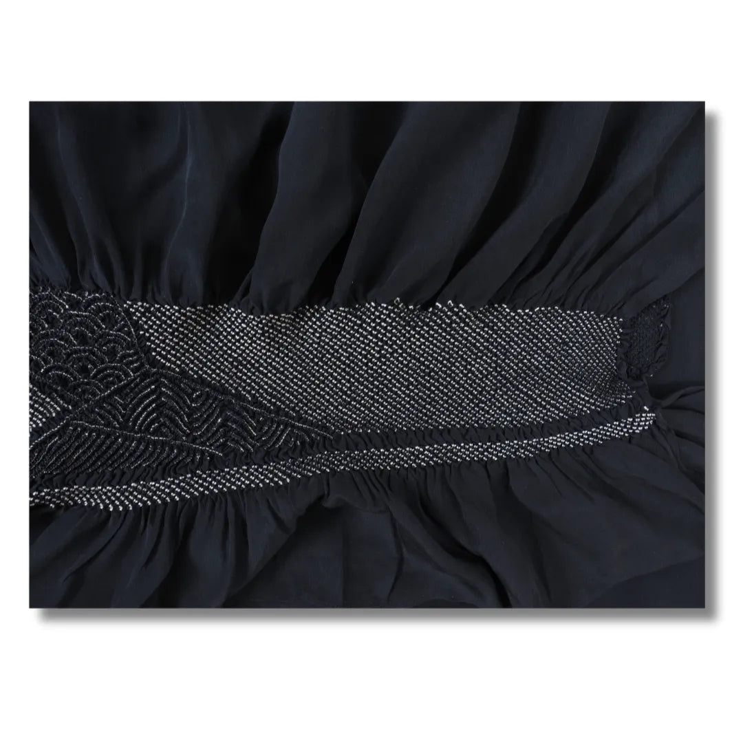 Weißes Punktfeld und Wellenbögen im Shibori zwischen nachtblauen Stoffrüschen
