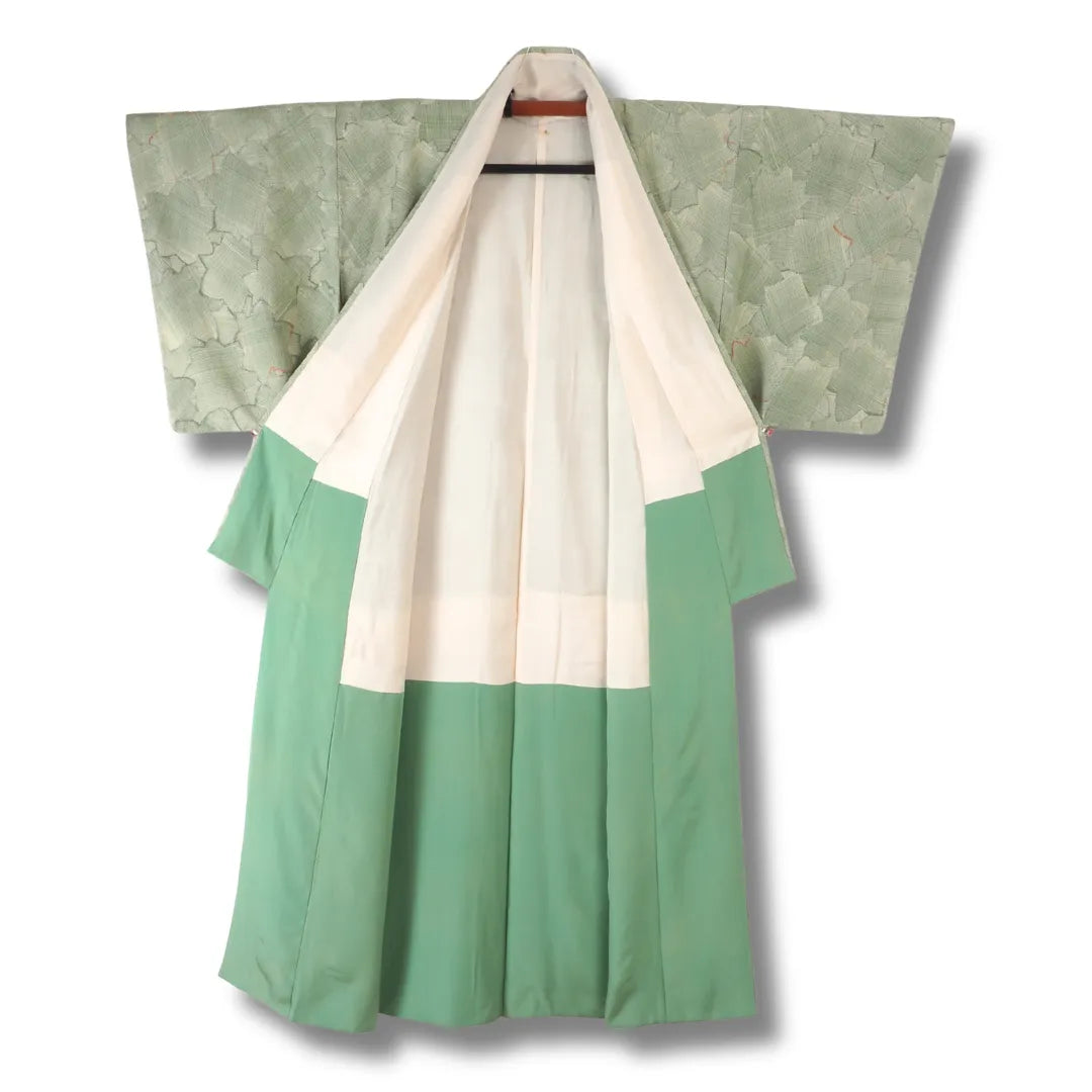 Vintage Komon-Kimono aufgehängt, grünes Futter mit cremefarbenem Übergang sichtbar