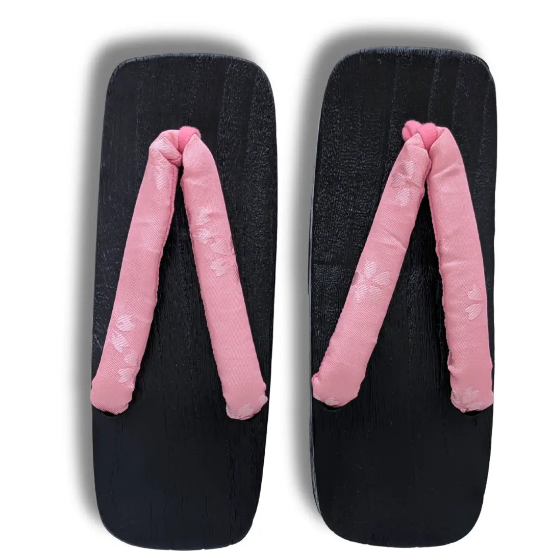 Traditionelle japanische Holzsandalen mit rosa Kirschblüten-Riemen und schwarzem Holzdesign