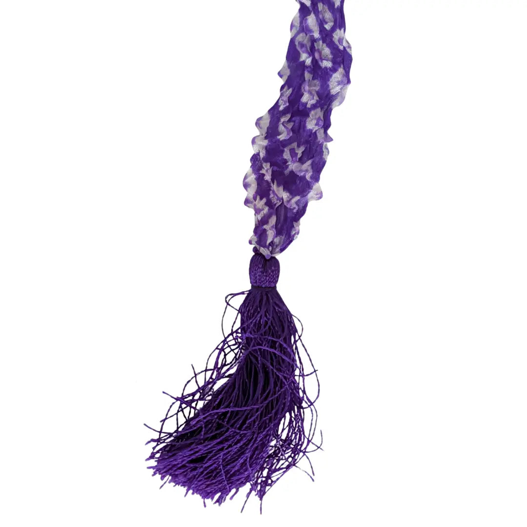 Nahaufnahme eines japanischen Vintage Chinkoro Haarbands in Lila mit geraffter Shibori Struktur und langer violetter Fadenquaste