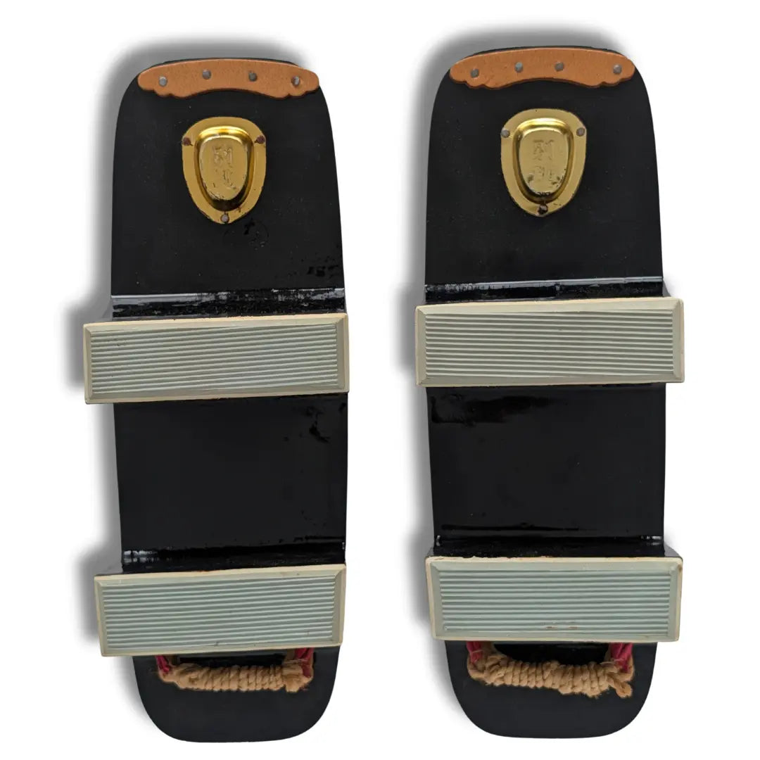 Unterseite der japanischen Vintage Geta mit hellen Gummiauflagen an den beiden Holzstegen und goldfarbenen Beschlägen