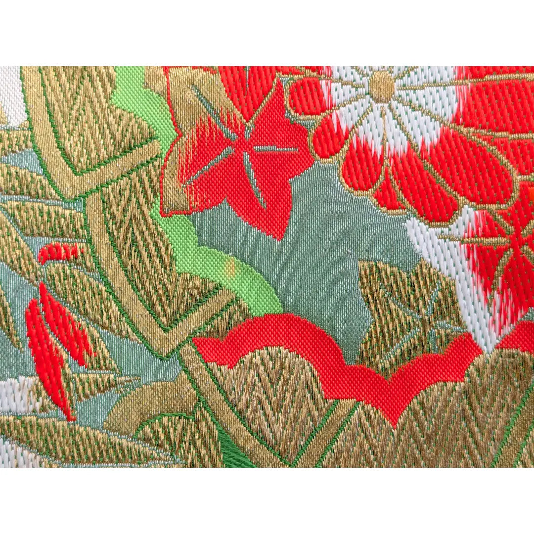 Makroaufnahme der gewebten Struktur eines japanischen Vintage Fukuro Obi mit roten Blüten