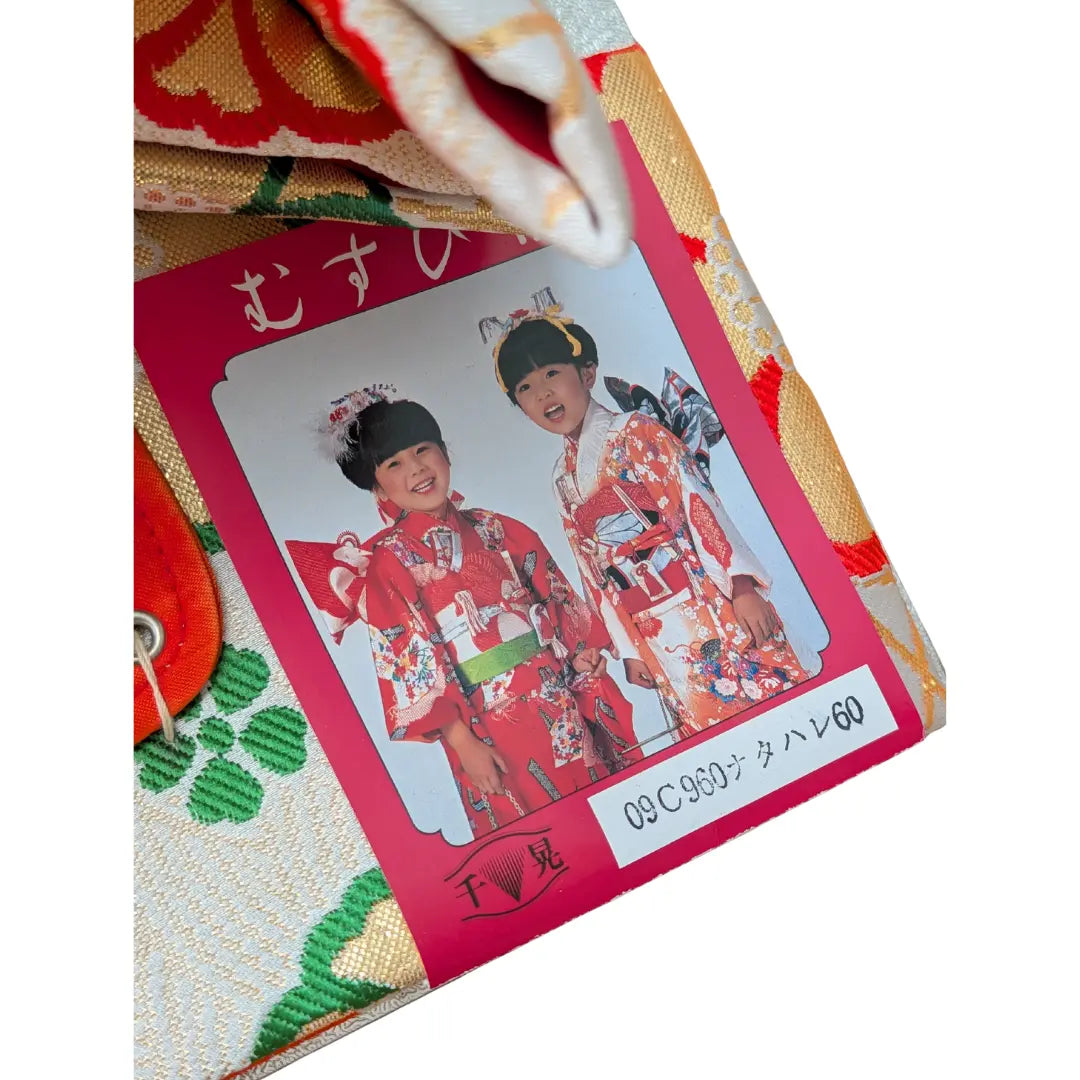 Shichi-Go-San Vintage Musubi Obi Schleife in Weiß mit roten Kordeln und traditionellen Blumenmustern.