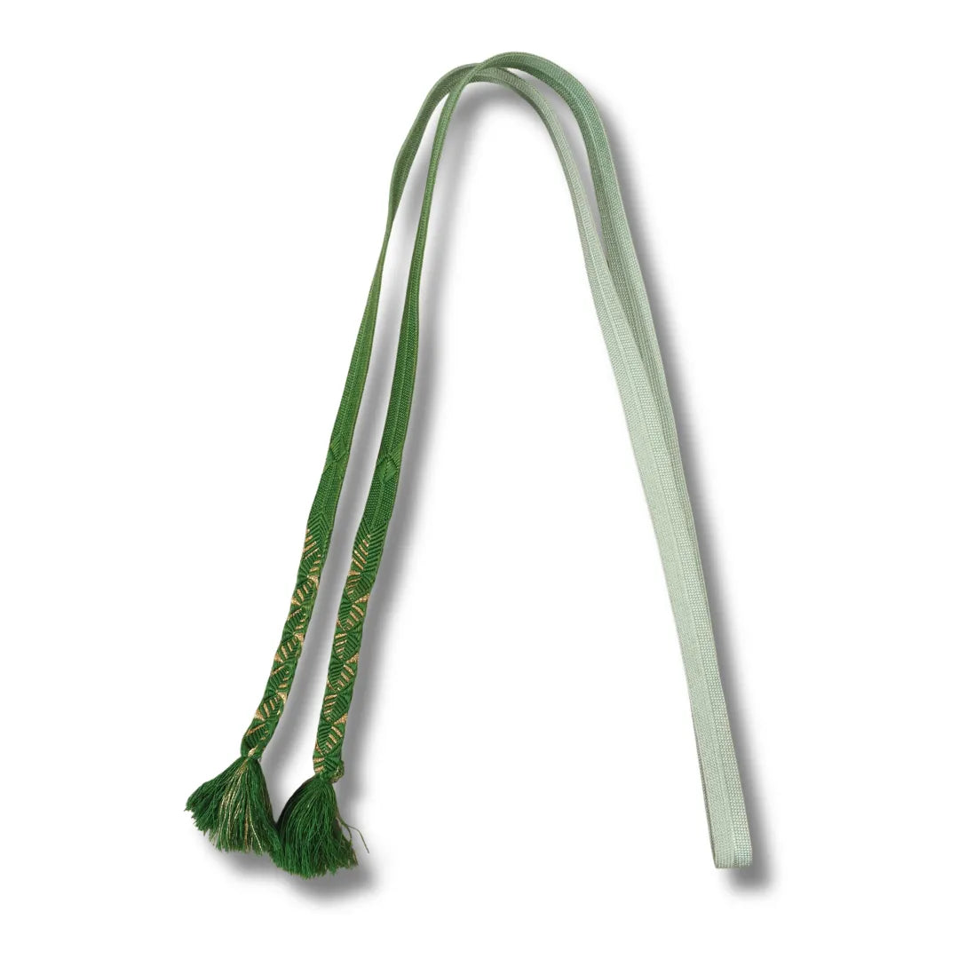 Breites flaches Band mit Verlauf von Dunkelgrün zu Blassgrün, als Bogen mit Quasten gelegt