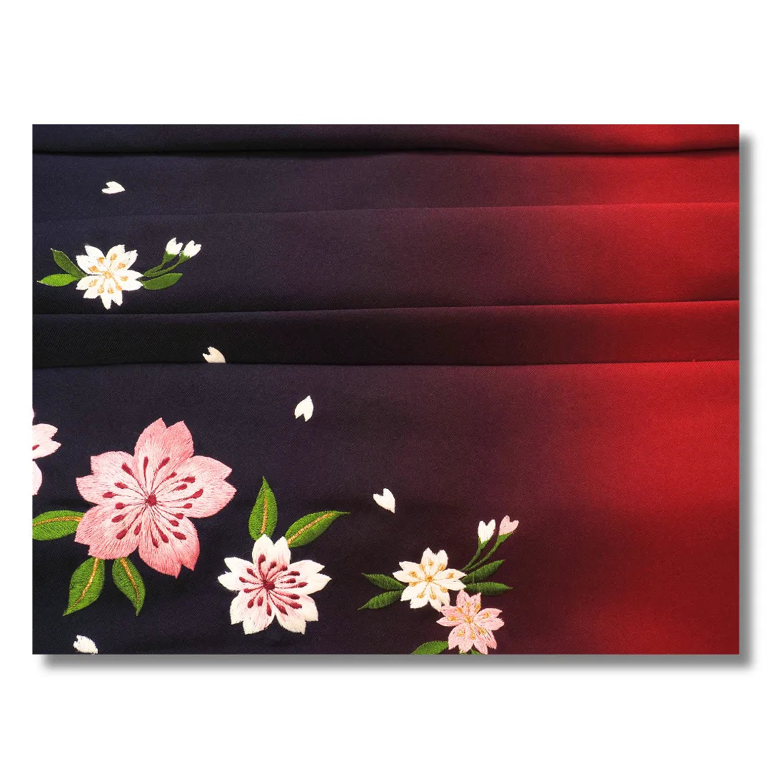 Detailaufnahme der Sakura-Stickerei mit rosa Blüten und grünen Blättern