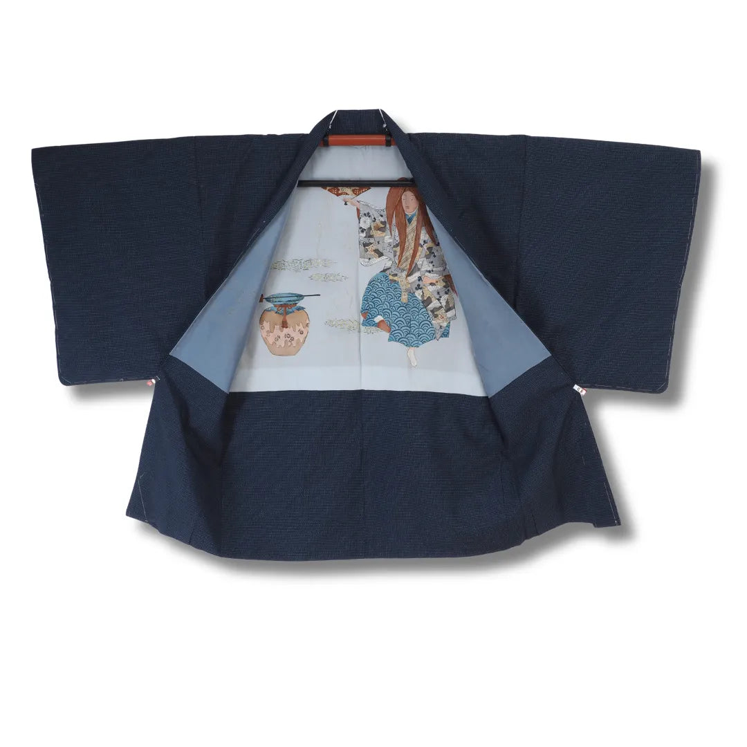 Dunkelblauer Haori aufgehängt mit geöffnetem Futter, Figurenmotiv teilweise sichtbar