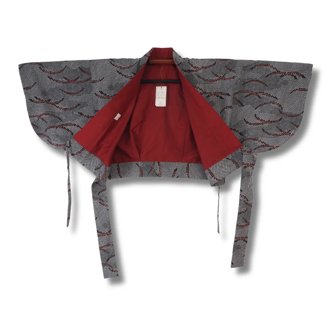 Geöffnete Haori-Jacke in Schwarz-Grau mit rotem Innenfutter und Etikett