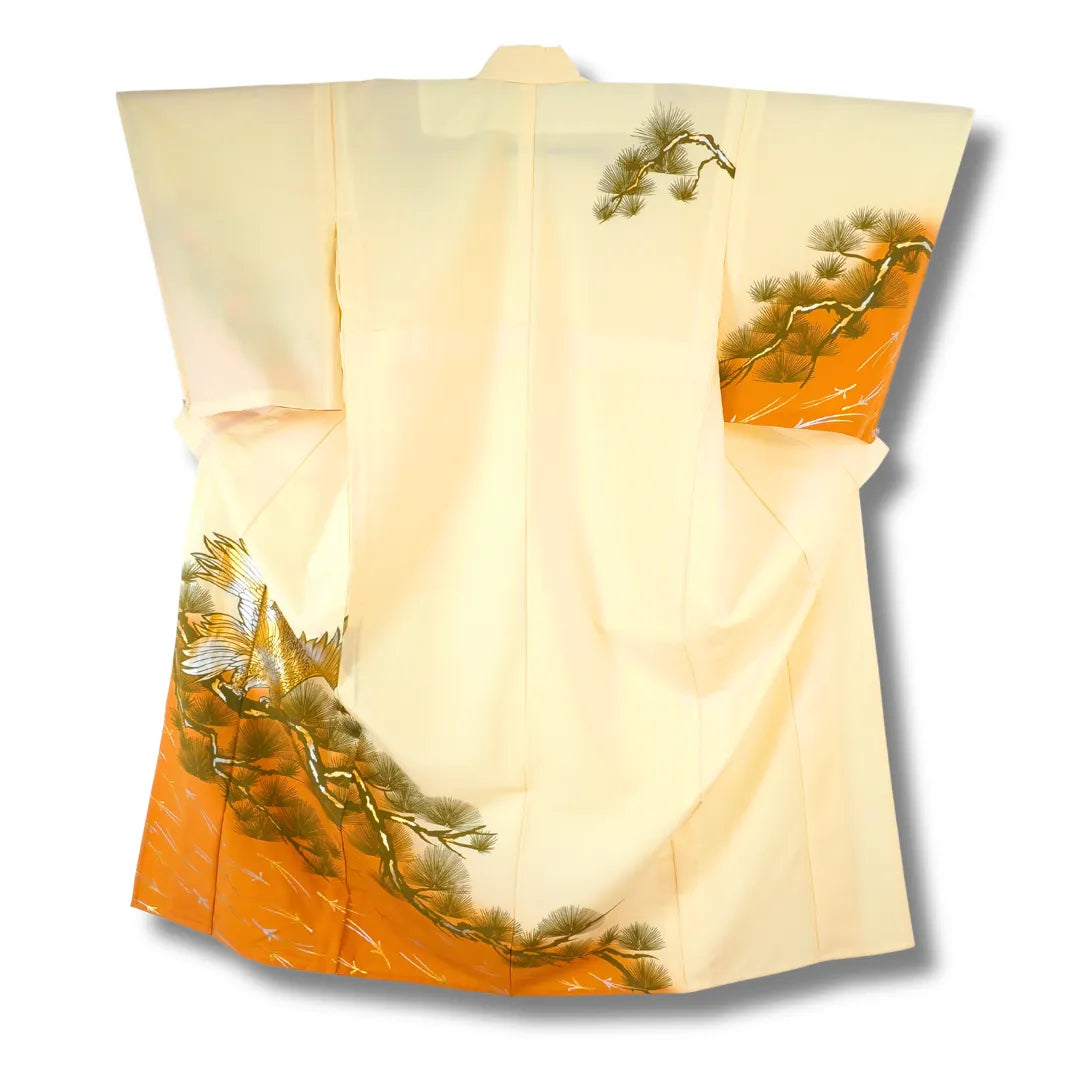 Hellgelber Vintage-Kimono hängend, oranger Saum mit Kiefernmotiv sichtbar