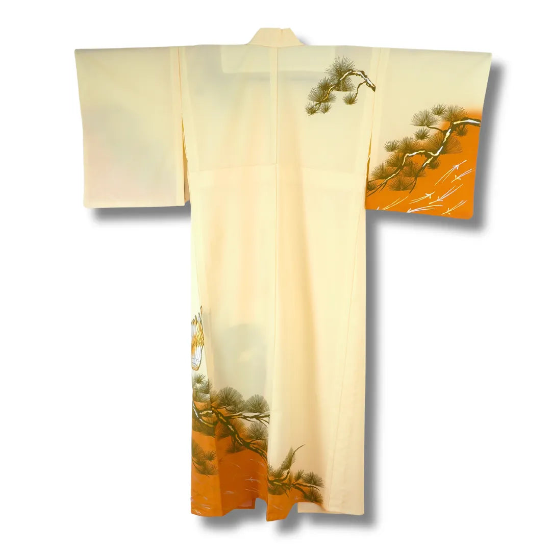 Hellgelber Vintage-Kimono hängend, oranger Saum mit Kiefernmotiv sichtbar