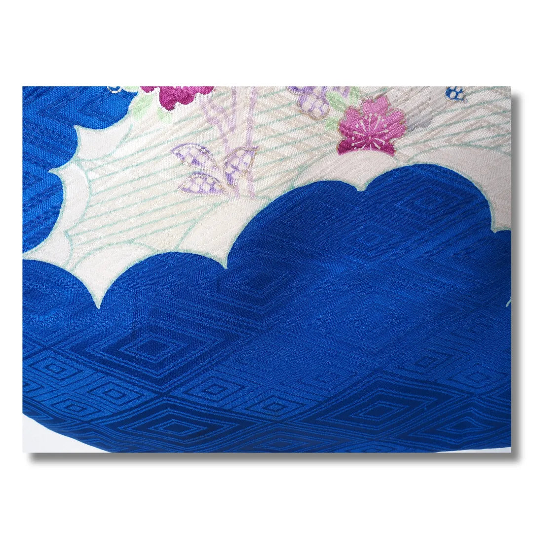 Nahaufnahme der weißen Wolkenformen mit Rautenmuster auf königsblauem Furisode-Stoff