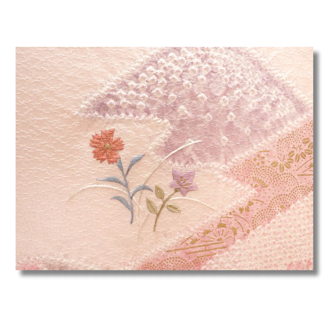 Nahaufnahme des Blütenmotivs in Rosa, Grün und Violett auf dem Kimono