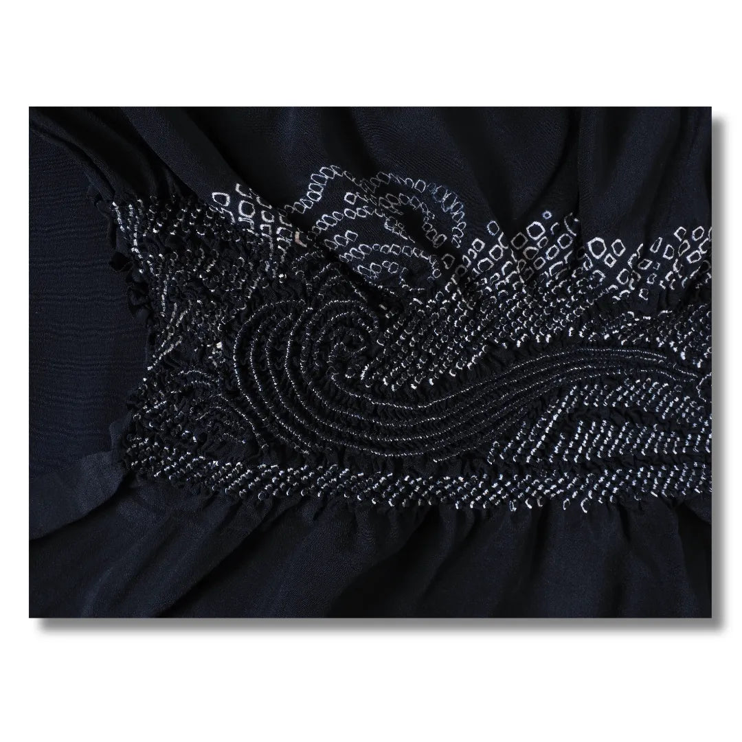 Nahaufnahme des Shibori-Musters mit geschwungenen Wirbeln und weißen Punkten