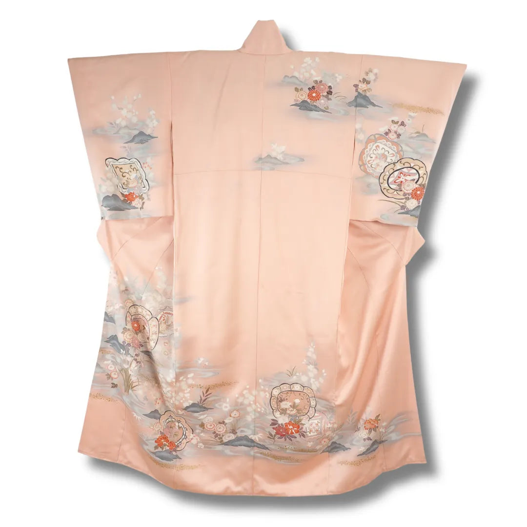 Rosafarbener Vintage-Kimono hängend, Blumenmuster am unteren Saum sichtbar
