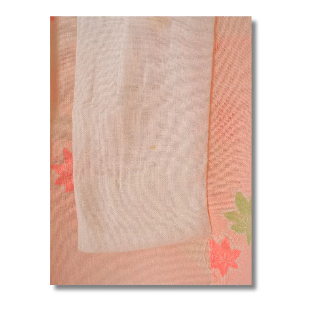 Detailaufnahme des floralen Musters mit pinken und grünen Blüten und Fleck am Kragen