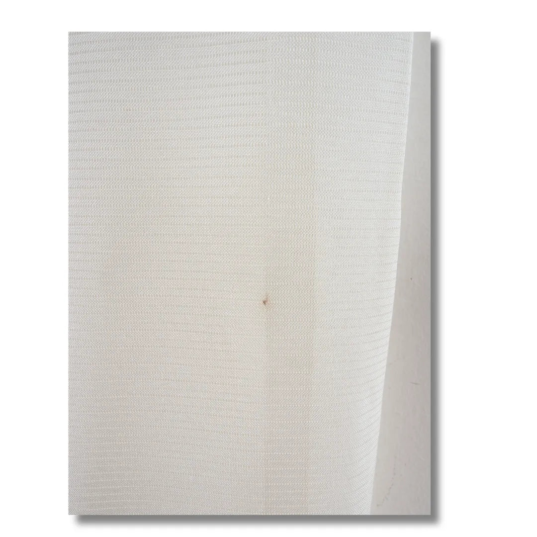 Detailaufnahme des Stoffes mit feinem Streifenmuster und winzigem Fleck