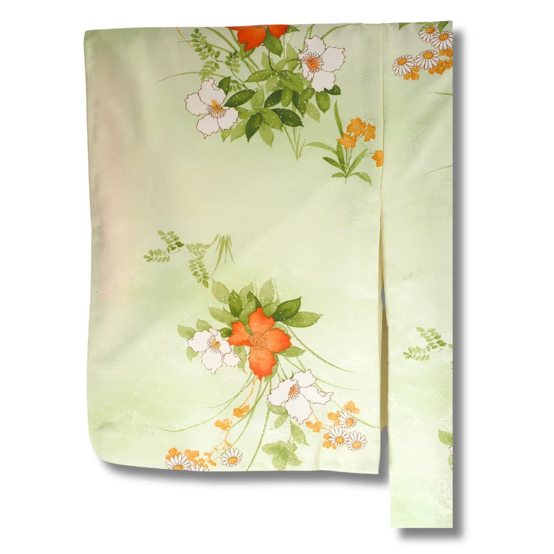 Detailansicht florales Muster in Weiß und Orange auf grünem Stoff
