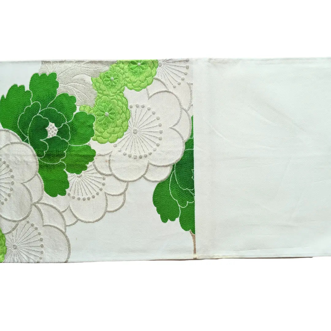 Vintage Fukuro Obi mit grünem Botan- und Ume-Muster neben hellem ungemustertem Bereich