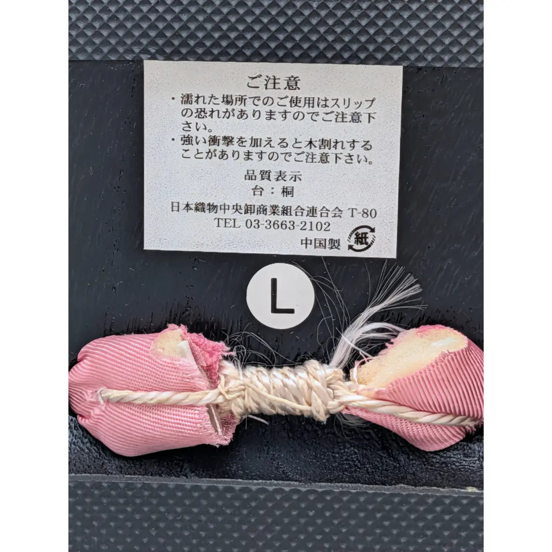 Detailaufnahme der traditionellen Befestigung japanischer Geta mit rosa Hanao-Riemen