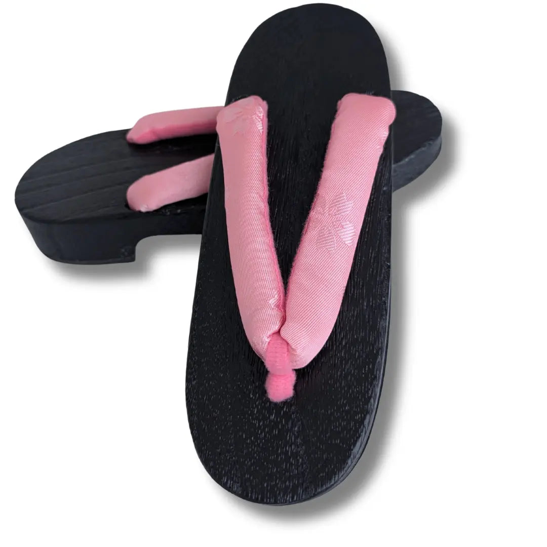 Traditionelle schwarze Geta aus Holz mit großen rosa Sakura-Blüten