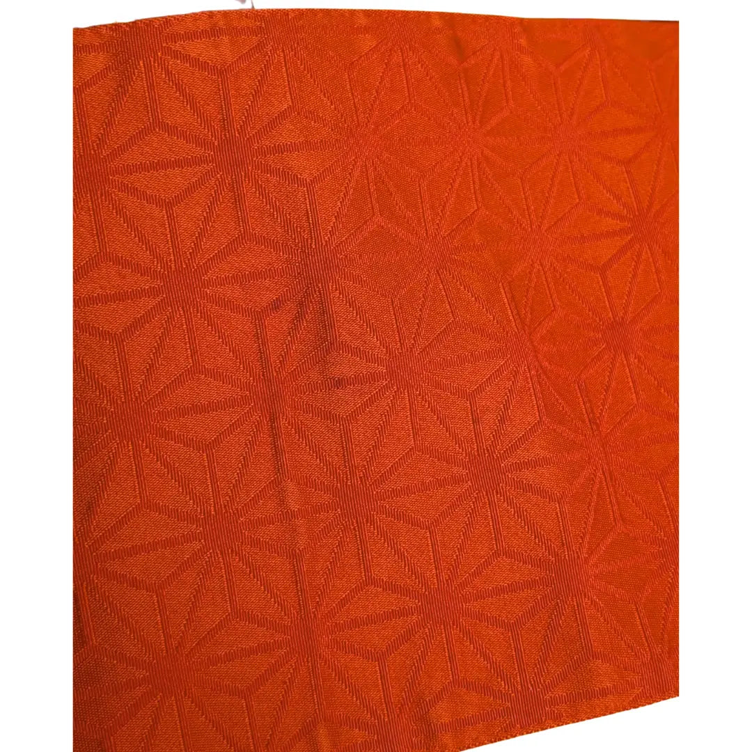 Orangefarbene Seite mit kleinen Flecken des Vintage Hanhaba Obi mit traditionellem Asanoha-Muster.