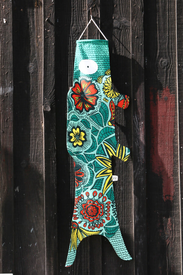 Koinobori Größe M mit Blüten vor einer braunen Holzwand #farbe_Blüten