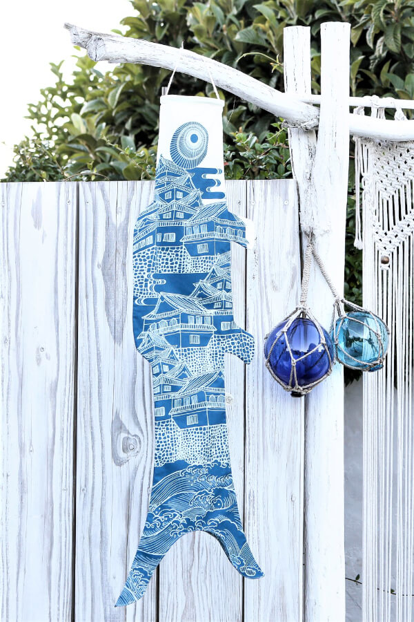 Koinobori Größe M Ôshiro in Blau hängt an einem weißen Zaun #farbe_Blau