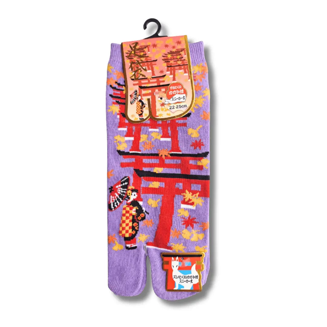Vorderseite der Verpackung: Lilafarbene Tabi-Socken mit geteiltem Zeh, traditionellem Geisha-Print und rotem Torii-Gate-Design. #farbe_Lila
