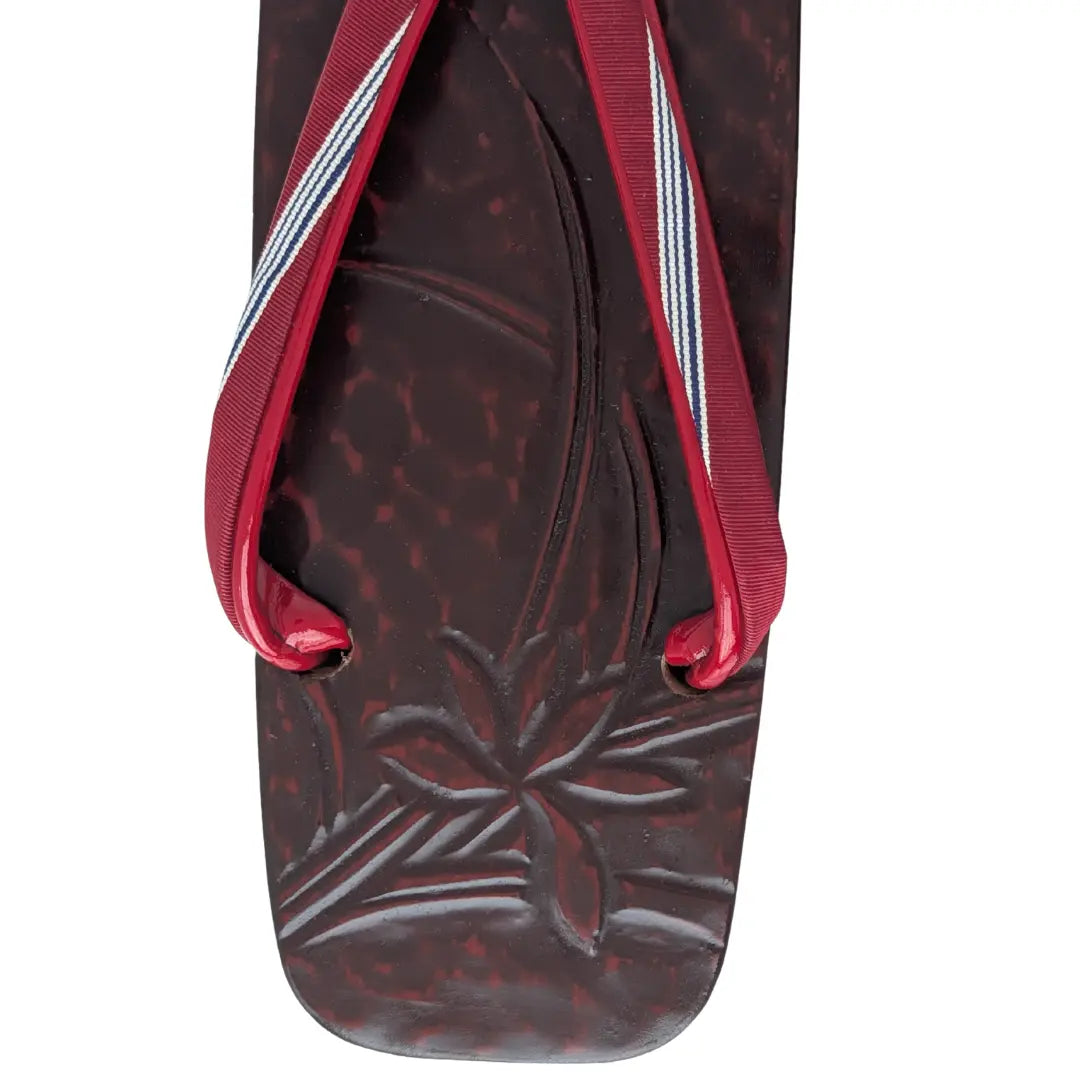 Detailaufnahme einer Vintage Geta mit Bambusmotiv und rot gestreiftem Hanao-Riemen