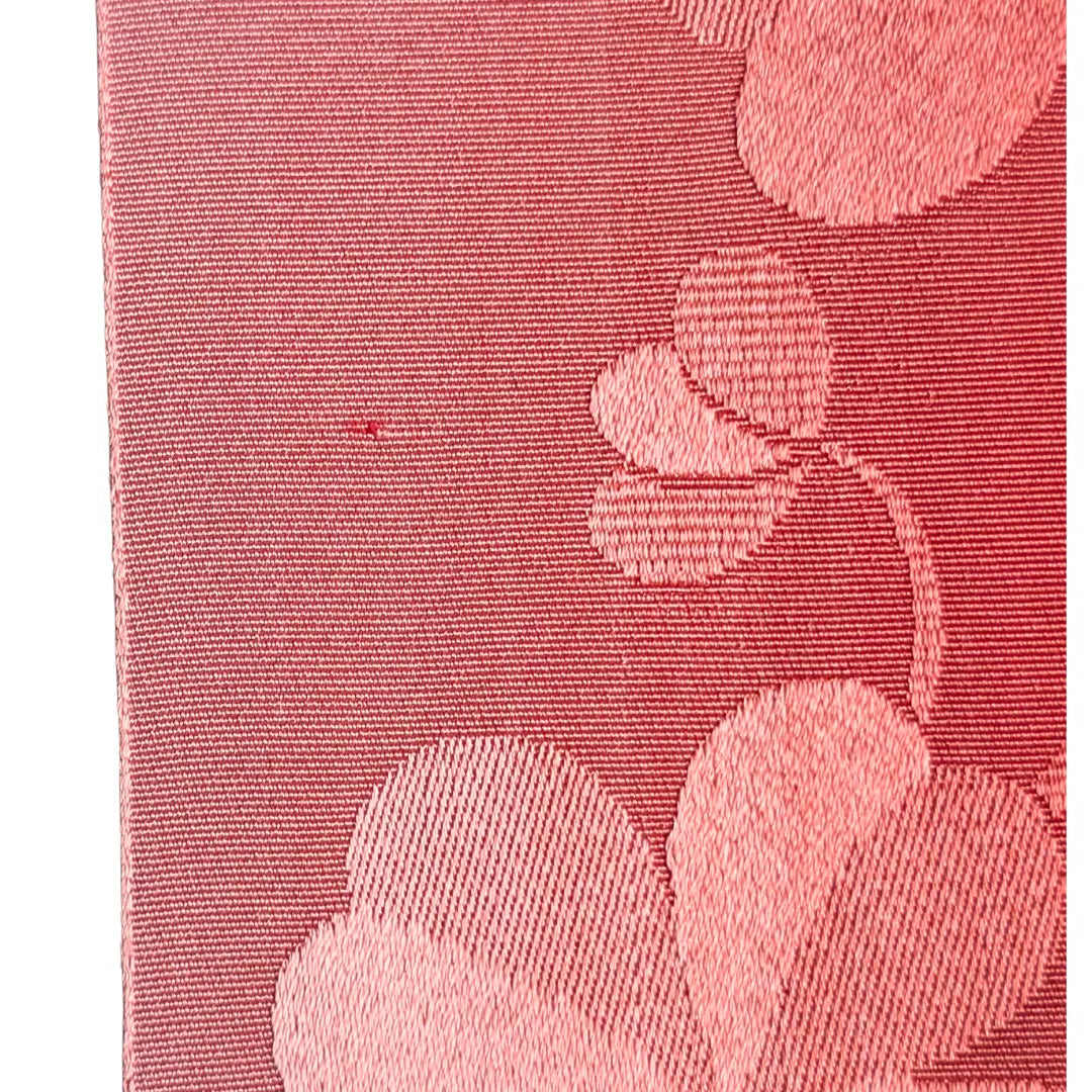 Detailaufnahme des rosa Hanhaba Obi mit eingewebtem Kleeblattmuster und Webfehler.