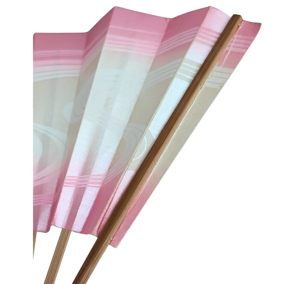 Detail japanischer Tanzfächer: weiße Wellenlinien auf rosa Washi-Papier neben unlackiertem Bambusstab