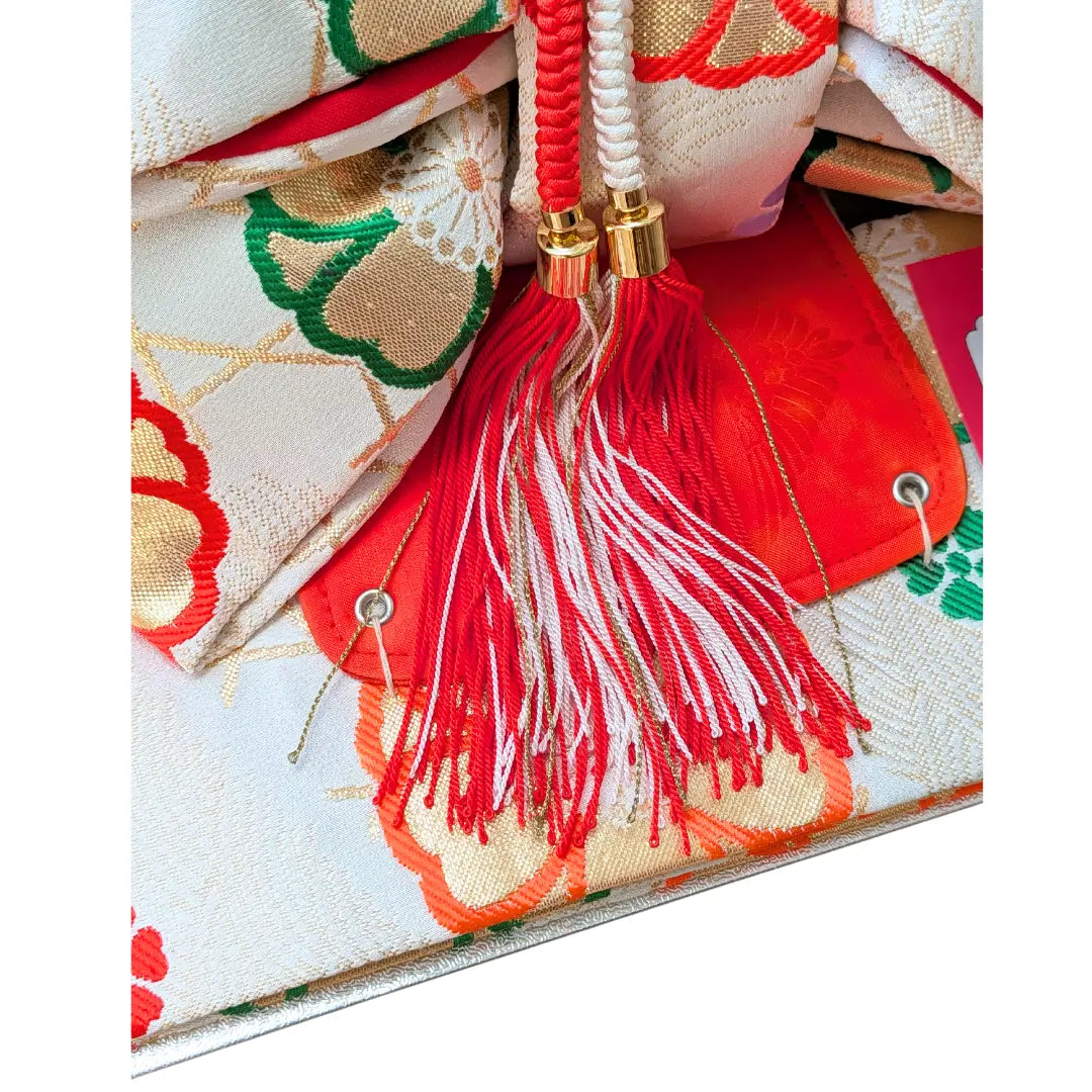 Ungetragene Vintage Musubi Obi Schleife in Weiß mit roten Kordeln und traditionellen Blumenmustern.