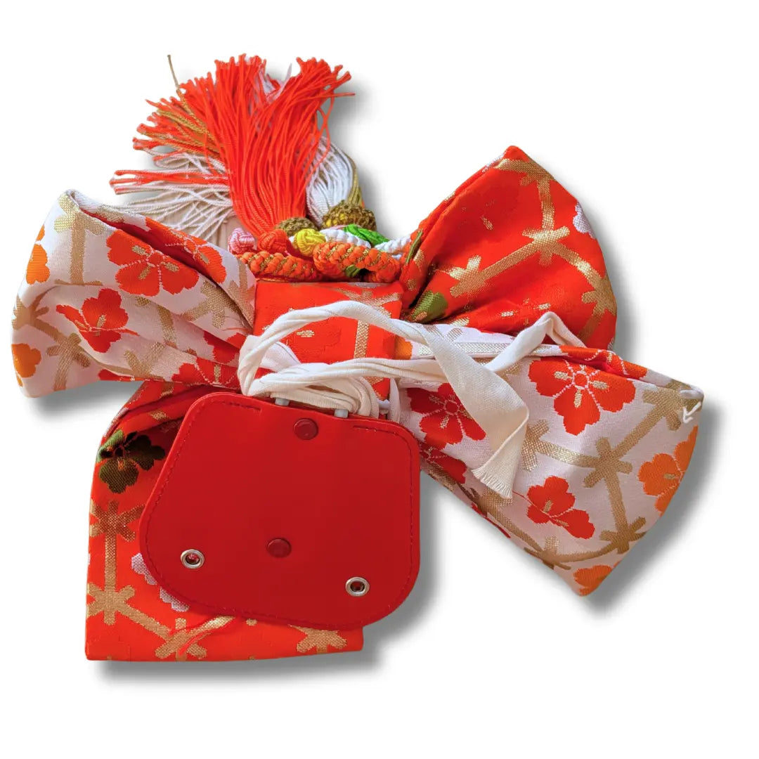 Detail Vintage Musubi Obi Schleife mit traditionellem Hanabishi-Muster in Orange und Gold.