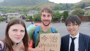 Anni und Fabi trampen durch Japan mit einem Schild nach Imabari